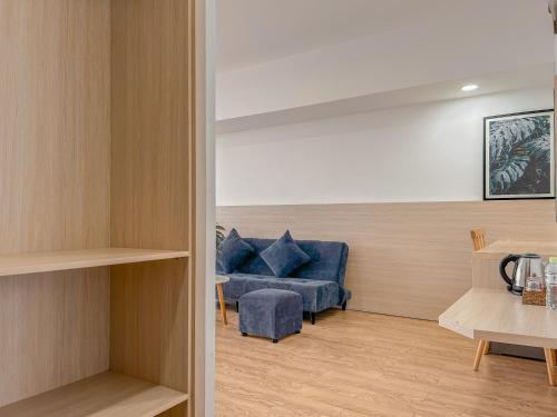 a living room with a blue couch and a table at Lux Nest hotel in Ấp Kim Thạch