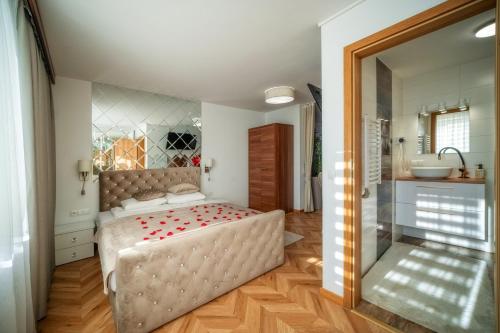 a bedroom with a large bed and a bathroom at GORSKI RESORT Lux Apartments Jacuzzi & Sauna in Poronin