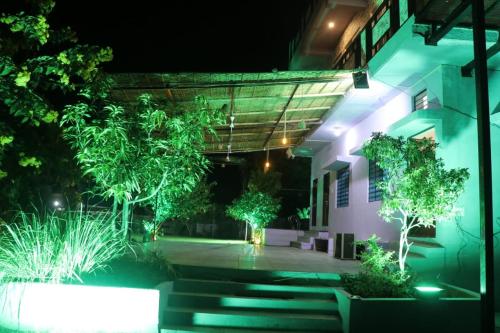 a night view of a building with trees and stairs at Darshan Villa in Thūr
