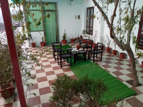 a patio with tables and chairs on a checkered floor at Ghala Residency in Munnar