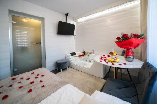 a room with a bed and a table with flowers on it at GORSKI RESORT Lux Apartments Jacuzzi & Sauna in Poronin