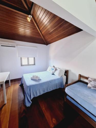 a bedroom with two beds and a wooden ceiling at Apartamento Exclusivo Búzios Centro in Búzios