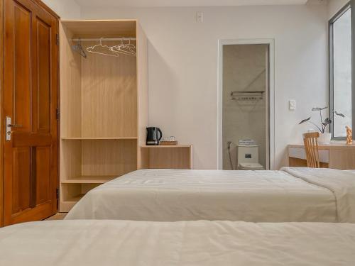 a bedroom with a white bed and a closet at Lux Nest hotel in Ấp Kim Thạch