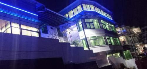 a large building with blue and green lights on it at Ghala Residency in Munnar