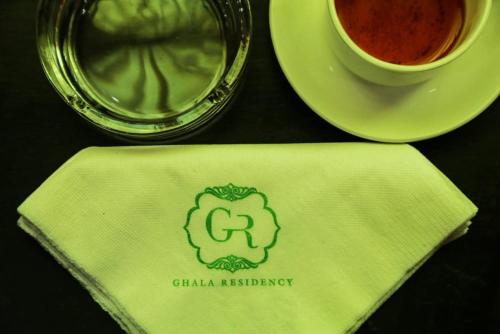 a table topped with a napkin with a cup of coffee at Ghala Residency in Munnar