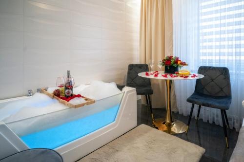 a hotel room with a tub and a table and chairs at GORSKI RESORT Lux Apartments Jacuzzi & Sauna in Poronin