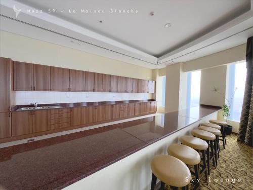 a row of stools in a large room with a bar at Huzz 59 - La Maison Blanche in Dubai