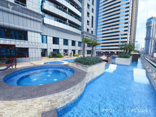 a large swimming pool in front of a building at Huzz 59 - La Maison Blanche in Dubai