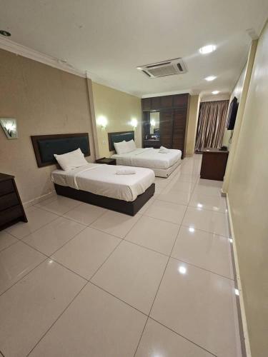 a hotel room with two beds in a room at Kesuma Villa Parit Raja in Parit Raja