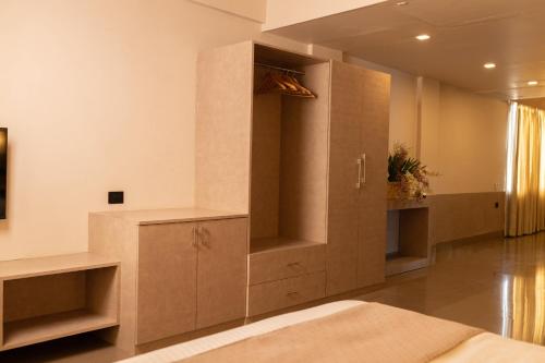 a bedroom with a large wooden cabinet in a room at The Layover Hotel in Dimapur