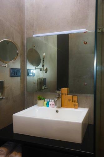 a white sink in a bathroom with a mirror at The Cube in Kegalle