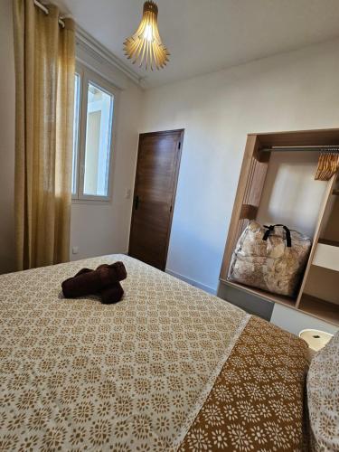 une chambre avec un lit avec un animal en peluche dessus dans l'établissement Les élégantes colonnes de la Place Saint Charles, à Nîmes