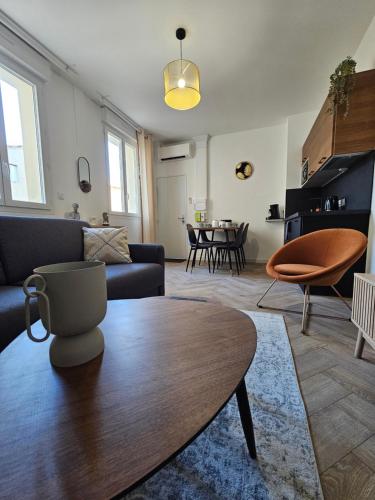 un salon avec un canapé et une table dans l'établissement Les élégantes colonnes de la Place Saint Charles, à Nîmes
