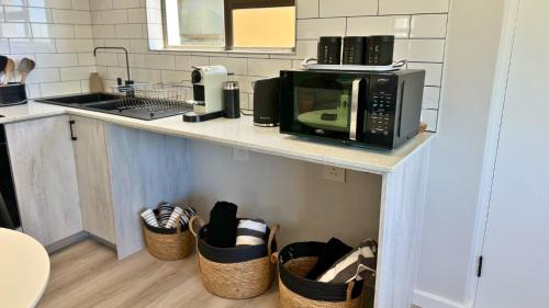 a kitchen with a microwave on a counter with baskets at Obs Centre Luxe Loft in Cape Town