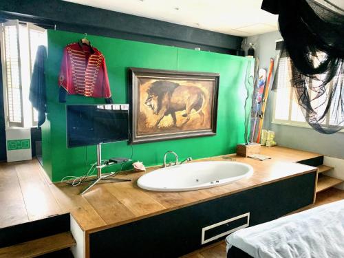 baño con lavabo y pared verde en Elegant penthouse LOFT of 250 m2 in city centre with huge roofgarden 80 m2, en Ámsterdam