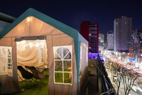 a tent on a balcony with a city at night at Mutal Stay in Seoul