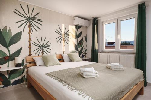 een slaapkamer met een groot bed met handdoeken erop bij Villa Mia - Moderne Oase mit Meerblick und Pool in Vodice