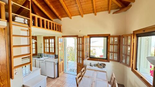 eine Küche mit Holzdecken und -fenstern sowie einem Waschbecken in der Unterkunft Villa OCHRA - schöner Balkon mit Meerblick in Koroni
