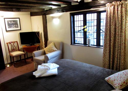 a bedroom with a bed and a chair and a television at Pemberton House in Lincoln