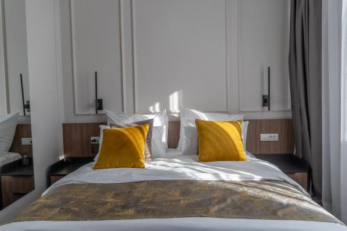 a bedroom with a large bed with yellow pillows at Hotel Rajska dolina Jahorina in Jahorina