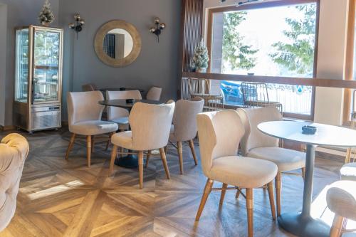 a restaurant with tables and chairs and a mirror at Hotel Rajska dolina Jahorina in Jahorina