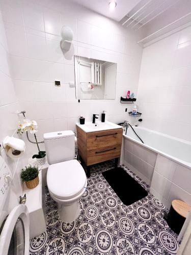 a bathroom with a toilet and a sink and a tub at Apartament Sieroszewskiego in Puławy