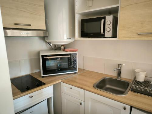a kitchen with a sink and a microwave at Le Nid plein centre in Salon-de-Provence