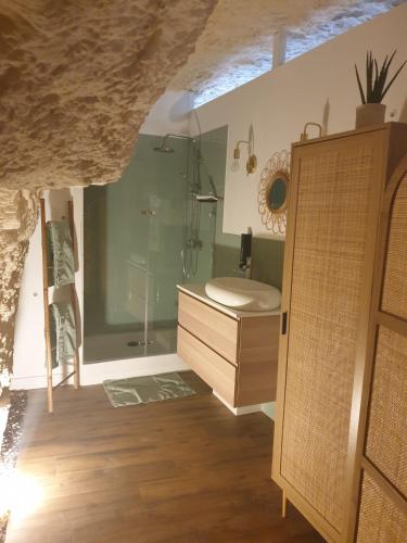 La salle de bains est pourvue d'une douche et d'une armoire en bois. dans l'établissement La Grotte du Bonheur, à Cangey