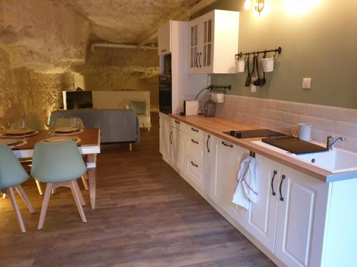a kitchen with a table and a sink and a counter at La Grotte du Bonheur in Cangey