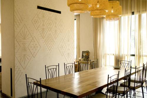a dining room with a large wooden table and chairs at Atlas Retreat Luxury Bed and Breakfast in Beni Mellal