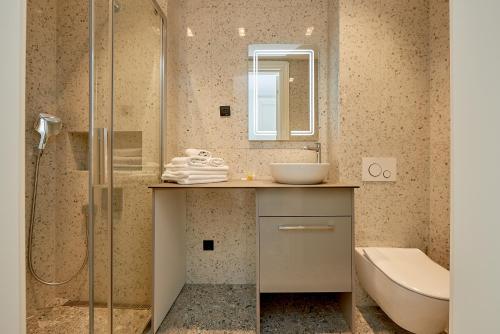 a bathroom with a sink and a toilet and a shower at Панорамная квартира на первой линии моря Skyline Resort, Becici, Budva in Becici