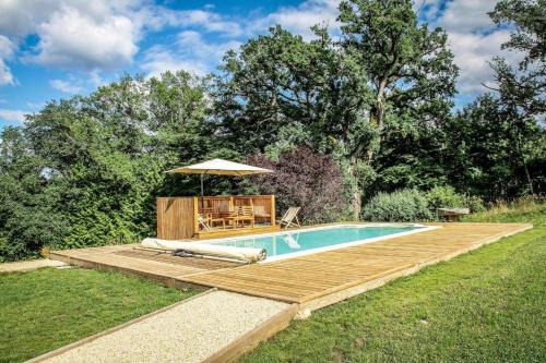 une piscine avec une terrasse en bois et un parasol dans l'établissement Domaine de Maisonneuve, à Sugères