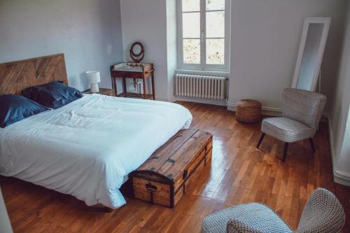 une chambre avec un lit, une table et des chaises dans l'établissement Domaine de Maisonneuve, à Sugères