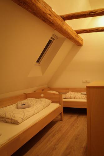 two beds in a room with wooden beams at Ferienwohnung Bauernhaus 3 in Balingen