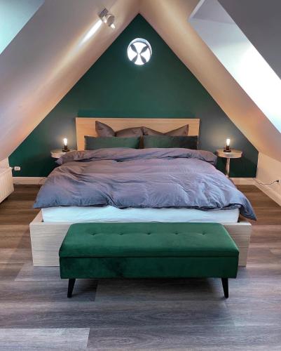 a bedroom with a large bed with a green wall at Pauerhof Ferienwohnungen in Bad Nenndorf