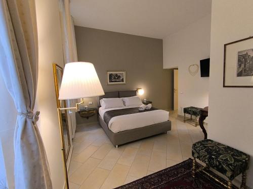 a bedroom with a bed and a lamp at Maison Rebecca - Superior Suite Apartment in Ravenna