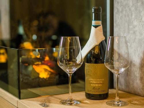 two wine glasses sitting next to a bottle of wine at Panoramahotel Grobauer in Spiegelau