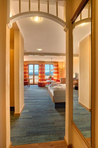 a hotel room with a bed and a living room at Panoramahotel Grobauer in Spiegelau