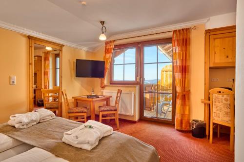 a hotel room with two beds and a table at Panoramahotel Grobauer in Spiegelau