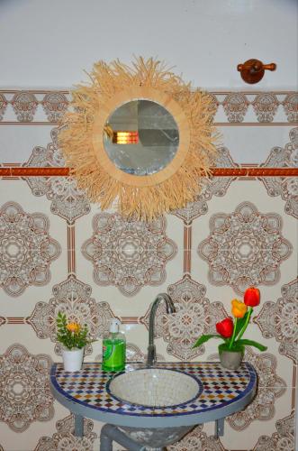 a bathroom with a sink and a mirror on a wall at DarnA in Inezgane