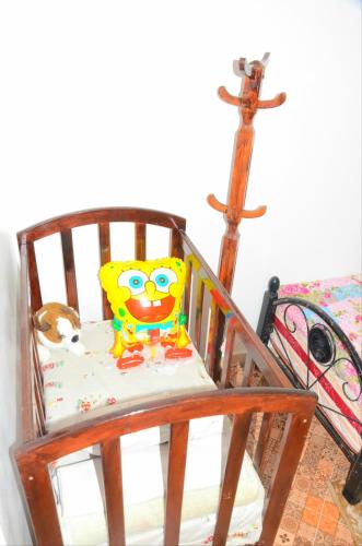a wooden rocking chair with a toy in it at DarnA in Inezgane