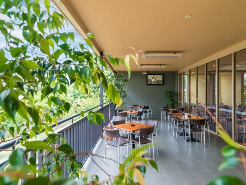 a cafeteria with tables and chairs and windows at Royal Hotel in Springwood