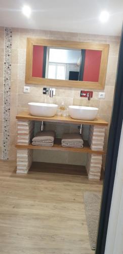 a bathroom with two sinks and a mirror at Chez Alexandra in Louchats
