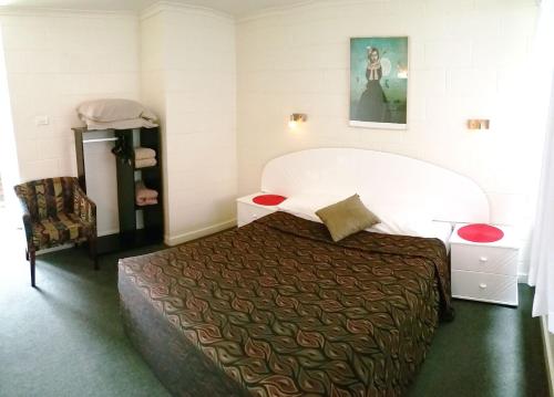 ein Schlafzimmer mit einem großen Bett in einem Zimmer in der Unterkunft A&A Lodge Motel in Emerald