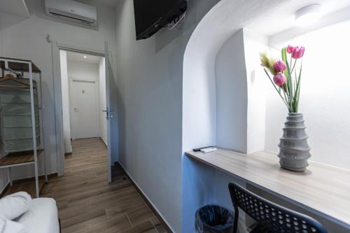 un soggiorno con un vaso di fiori su un bancone di Al castello-independent house a Catania