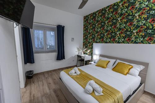 una camera da letto con un letto grande con asciugamani sopra di Al castello-independent house a Catania