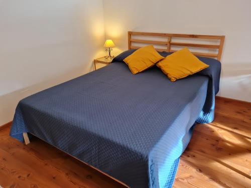 niebieskie łóżko z 2 żółtymi poduszkami w pokoju w obiekcie Haus Emma by Globalimmoservice w mieście Bad Kleinkirchheim