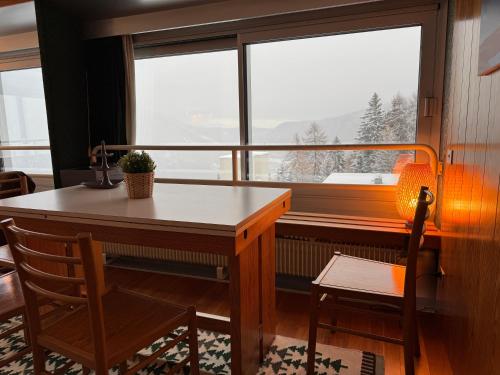 a table and chair in a room with a large window at Panorama Marilleva 1400 - Val di Sole in Marilleva