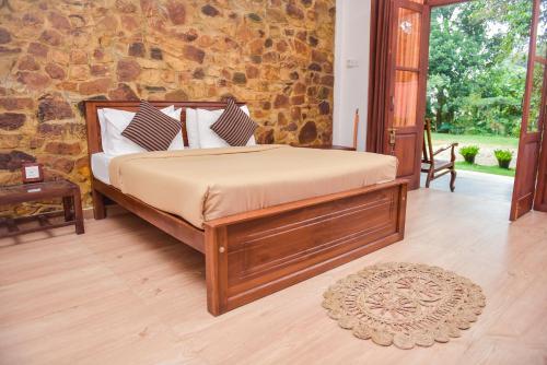 a bed in a room with a stone wall at The Residence Ella in Ella