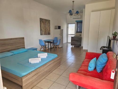 a bedroom with a bed and a red couch at Sea Apartments in Larnaka